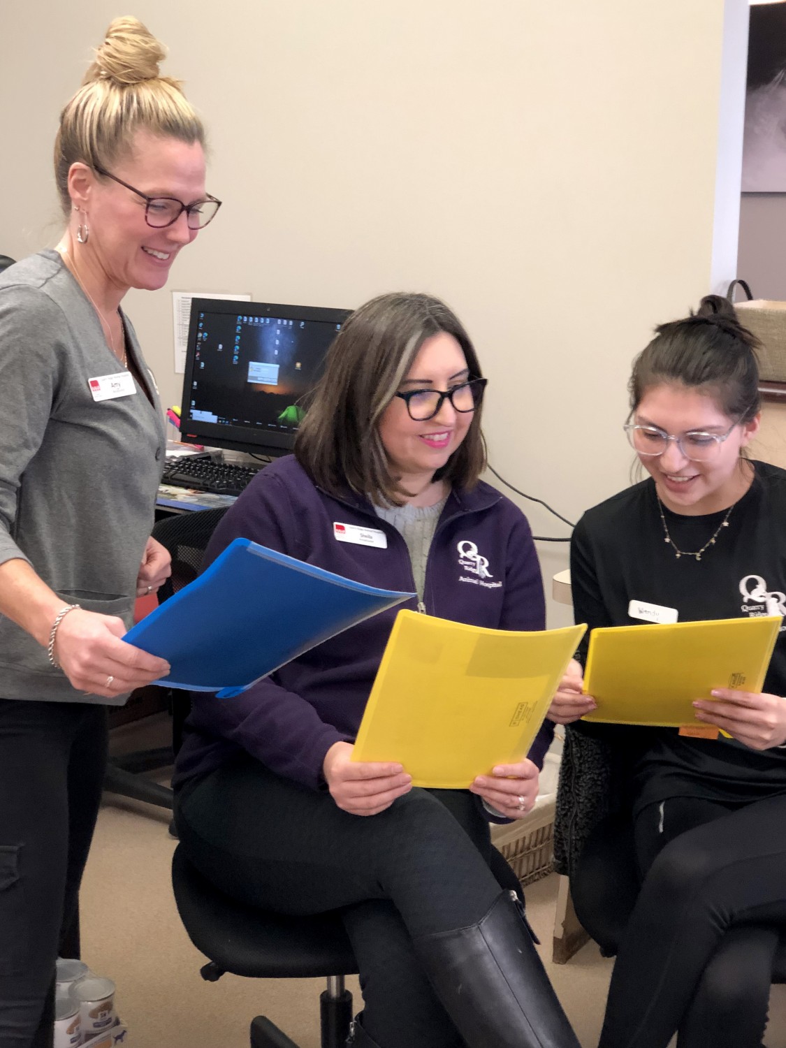 Receptionists Amy, Sheila, and Wendy review pets' paperwork at Quarry Ridge Animal Hospital